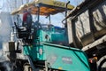 Road construction works on paving, road rollers compacting fresh asphalt over the entire width of the roadway